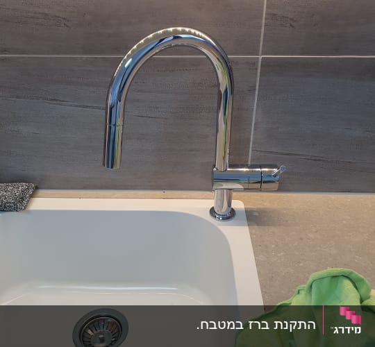 ברז נירוסטה מעל כיור מטבח לבן